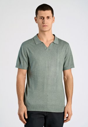 Polo shirt vert clair à manches courtes avec un col en V, texture en maille et ourlet côtelé. Design uni sans motifs ni accents visibles.