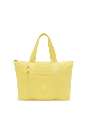 Gul kviltad tote-väska med två tyghandtag, en liten charm och en präglad logotyp på framsidan. Har en rymlig huvudfack.