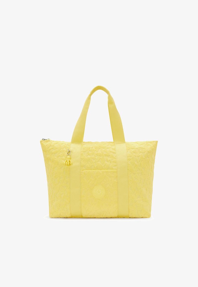 Gul quiltet taske med to stofhåndtag, en lille charm og et præget logo på forsiden. Har et rummeligt hovedrum.