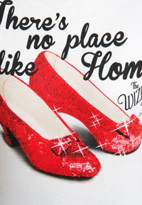 Red sequined high heels with a rounded toe and small embellishments, set against a light background. Text overlays the design.