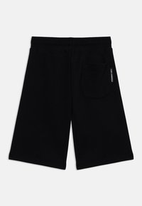 Zwarte shorts van zacht materiaal, met een achterzak en een elastische tailleband. Eenvoudig ontwerp zonder zichtbare patronen of accenten.