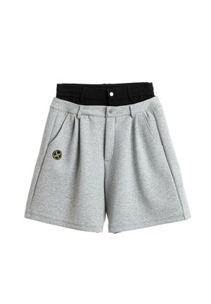 Dos pares de pantalones cortos, uno gris con botón y trabillas para cinturón, y uno negro con cintura elástica superpuestos, sobre un fondo blanco.