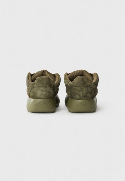 Olive green suede sneakers with rounded backs, padded collars, and rubber soles. Textured upper and embossed logo on the heel.