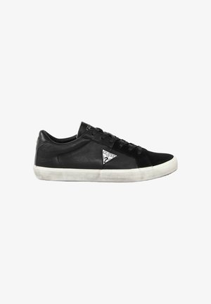 Baskets basses noires avec semelle en caoutchouc blanche, fermeture à lacets et logo triangle Guess sur la partie latérale, montrées de profil gauche.