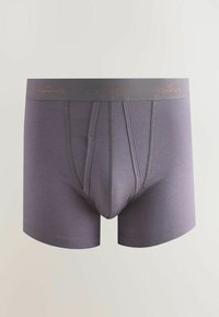 Lila boxeralsó sima textúrával, szürke derékpánttal, melyen narancssárgával "NEXT SIGNATURE" felirat található. Középen elöl varrással.