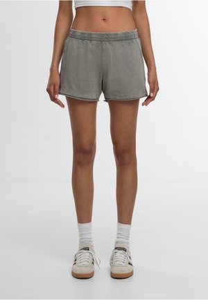 Grey cotton shorts with an elastic waistband, relaxed fit, and hemmed edges. Paired with white socks and sneakers on a plain background.