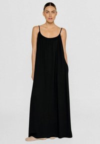 Schwarzes Maxikleid mit dünnen Trägern, gerafftem Ausschnitt, lockerer Passform und Seitentaschen. Hergestellt aus weichem, fließendem Stoff, der bis zu den Knöcheln reicht.