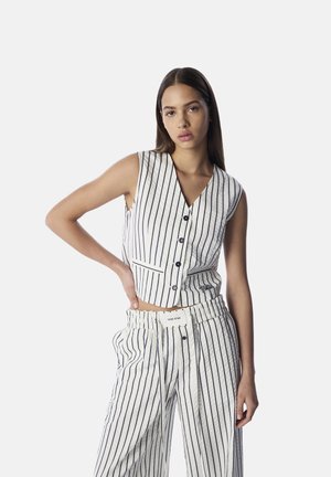 Ärmellose, gekürzte Weste und weit geschnittene Hose in Creme mit navyblauen vertikalen Streifen. Mit Knöpfen, einem V-Ausschnitt und einem elastischen Bund.