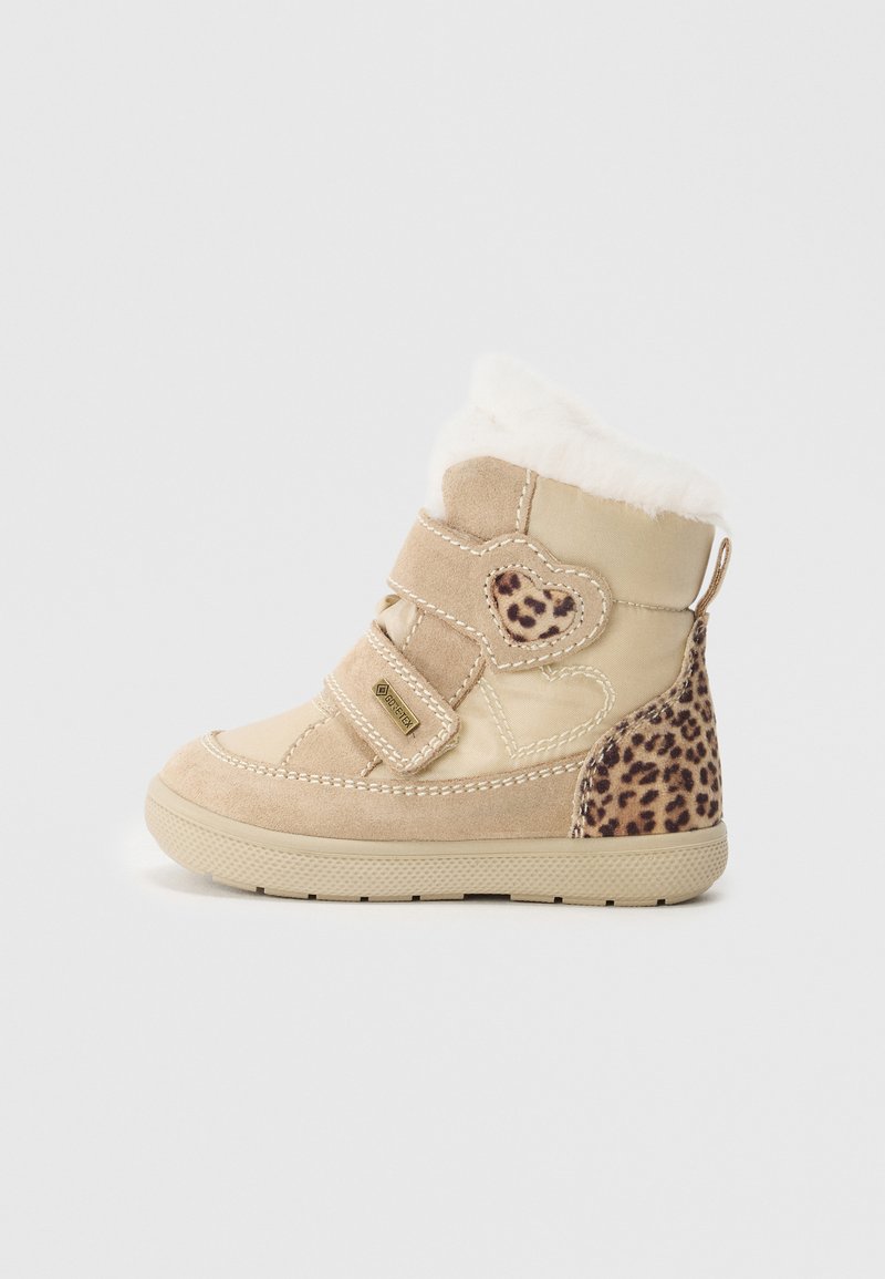 Beige vinterstøvel med faux fur-detaljer, materialer i semsket skinn og lær, borrelåsstropper og en leopardmønsterdetalj ved hælen. Flat såle.