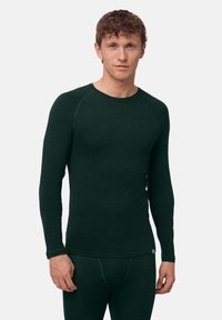 Thermisch shirt met lange mouwen in donkergroen, gemaakt van zachte stof. Heeft een ronde halslijn en een aangesloten pasvorm met geribbelde accenten op de mouwen.