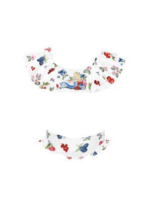 Bela bikinija zgornji del s cvetnimi in sadnimi motivi, ki ima naborke na rokavih in ilustracijo deklice. Mehka tkanina z gladko teksturo.