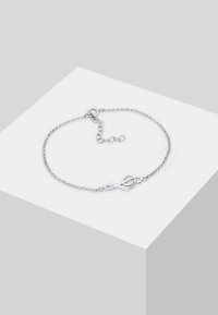 Pulsera de cadena de plata con cierre de bucle continuo, eslabones intrincados y longitud ajustable con un acabado delicado.