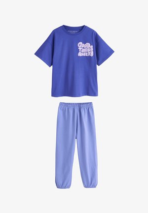 Lila Kurzarmshirt mit dem Aufdruck "Good Times Ahead" kombiniert mit hellvioletten Hosen mit elastischem Bund, die zusammen ein passendes, lässiges Lounge-Set bilden.