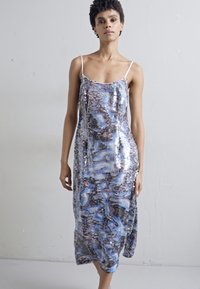 Rochie fără mâneci, realizată dintr-un material cu paiete, având un model strălucitor în nuanțe de albastru, negru și argintiu, cu o siluetă fluidă.