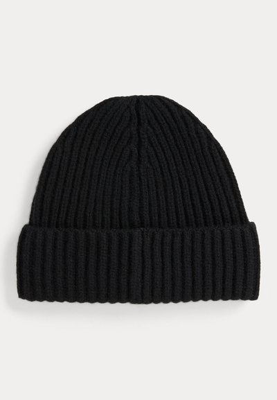 Melnā adīta beanie cepure ar ribotu tekstūru, ar salocītu maliņu un noapaļotu kroņu dizainu. Izgatavots no maiga vilnas materiāla.