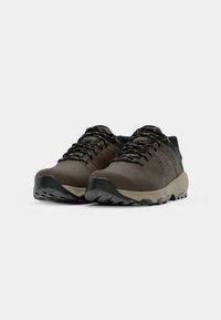 Low-profile hiking shoes in dark brown with black accents. Features a textured surface, patterned upper, durable outsole, and reinforced toe.
