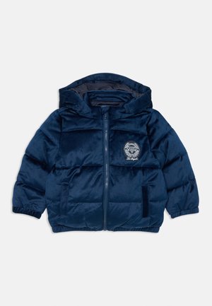 Navy blue puffer jacket with a hood, zip closure, elastic cuffs, and a circular logo on the chest. Soft, glossy texture with quilted pattern.