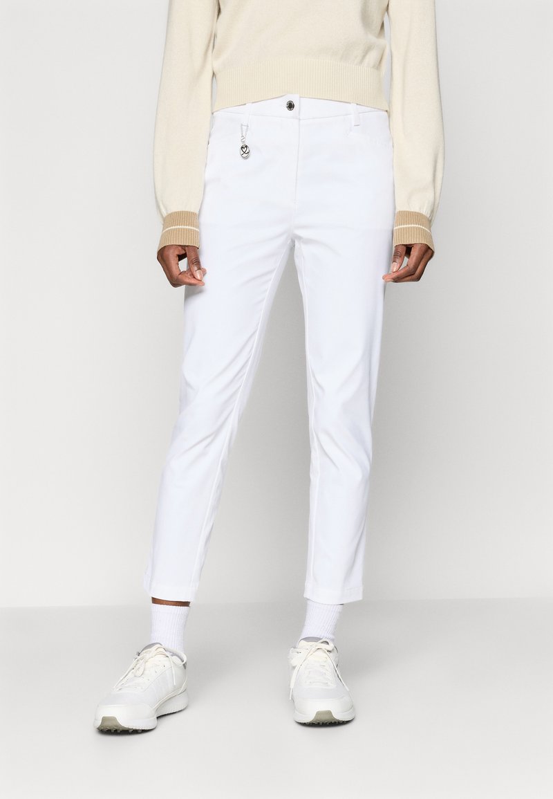 Hvite bukser med slim passform, med knappelukking foran, beltehull og et lite hjerteformet smykke. Glatt tekstur, minimalistisk design.