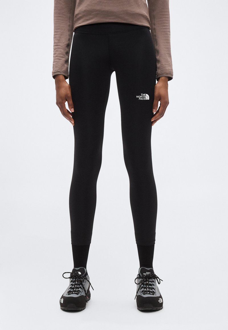 Μαύρο κολάν από ελαστικό υλικό με ψηλή μέση, με μικρό λευκό λογότυπο στη αριστερή πλευρά. Υφή στο πάνω μέρος.