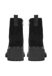 Botas de tobillo de ante negro con suela de goma texturizada, cremalleras traseras y tiradores reforzados. Presentan un diseño de tacón grueso.