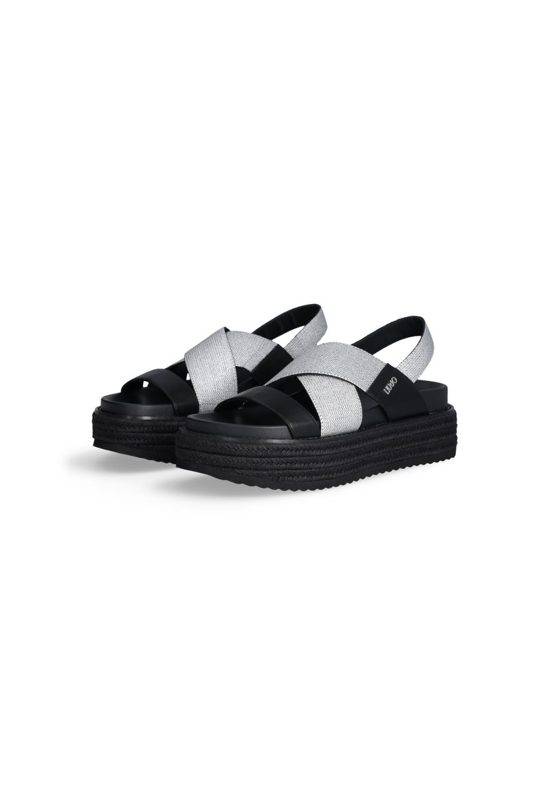Sandales plateformes noires et argentées avec des brides croisées en tissu texturé, une semelle en caoutchouc lisse et un détail tissé.