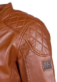 Bruine leren motorjack met gequiltte schouderdetails en een merkpatch. Glad materiaal met gestikte naden.