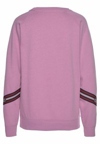 Rosa sweatshirt med raglanärmar, ribbad halsringning och nederkant. Har svarta och röda randiga detaljer på ärmarna, med varumärke på ena sidan.
