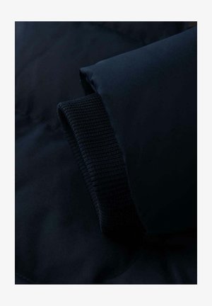 Tmavě modrá péřová bunda s žebrovaným pleteným manžetem a hladkým materiálem. Disponuje měkkou, lehkou texturou a minimalistickým designem.