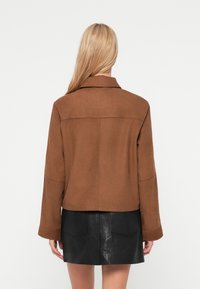 Καφέ σακάκι από μάλλινο μείγμα με γιακά, χαλαρούς ώμους και κουτί σχήμα. Διαθέτει καθαρή ραφή στην πλάτη και ελαφρώς υφασμένο ύφασμα.