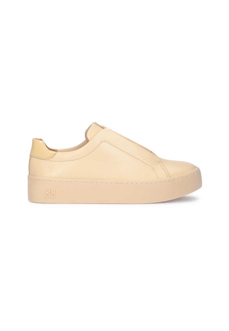 Beige bőr slip-on sneaker vastag platformtalppal, sima textúrával, minimalista dizájnnal és diszkrét márkajelzéssel a sarkán.