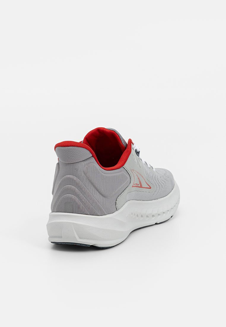 Zapatilla deportiva gris con parte superior texturizada, acentos rojos y suela blanca. Presenta un cuello acolchado y cordones en contraste para mayor soporte.