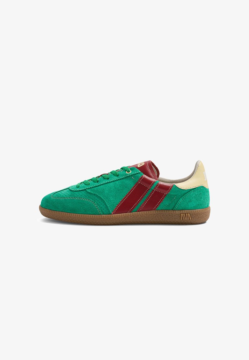 Baskets basses avec tige en daim vert, bandes en cuir rouge, languette de talon beige et semelle en gomme.