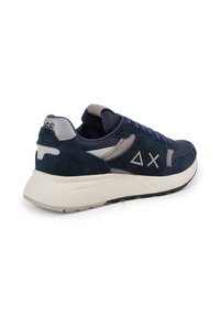 Sneakers in suede e mesh blu navy con accenti grigi e una suola bianca testurizzata. Presenta un logo triangolare e il nome del marchio sul lato.