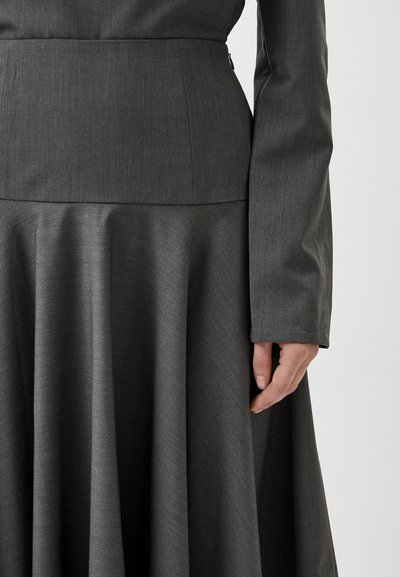 Gray dress featuring a fitted bodice and full skirt with pleats, made from textured fabric. Long sleeves with straight cuffs and discreet zipper.