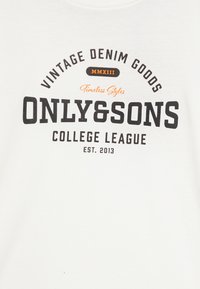 Hvit bomulls-t-skjorte med en svart og oransje grafisk tekstdesign som leser "VINTAGE DENIM GOODS ONLY&SONS COLLEGE LEAGUE EST. 2013."