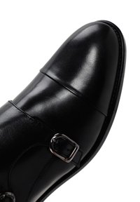 Zwarte leren nette schoen met een gladde, glanzende afwerking, voorzien van een dubbele gesp en een ronde neus.