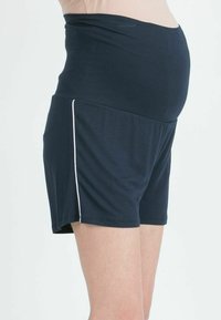 Shorts da maternità navy con una fascia elastica alta in vita. Realizzati in tessuto morbido e elasticizzato, dotati di tasche laterali e dettagli in piping bianco.