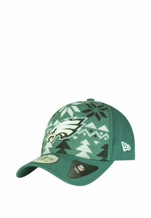Grüne Baseballmütze mit einem gemusterten Strickdesign, das weiße und schwarze Formen zeigt, Eagles-Logo auf der Vorderseite und Markenschild an der Seite.