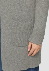 Grijze gebreide cardigan met een geribbelde textuur, een voorzak en brede mouwen, met een iets langere zoom aan de achterkant.