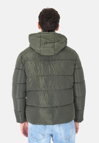 Giacca puffer verde oliva con cappuccio, caratterizzata da una finitura lucida e un design trapuntato. Presenta cuciture orizzontali e polsini elasticizzati.