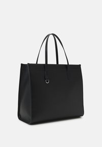 Černá taška typu tote s elegantním, strukturovaným designem, vyrobená z hladkého materiálu. Má dlouhé rukojeti, minimalistický tvar a jemné kovové detaily.