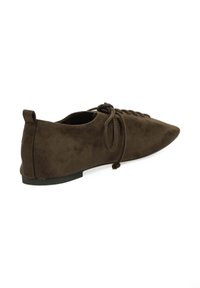 Zapato de ante marrón, punta afilada, tacón bajo y plano, diseño con cordones y detalle atado, perfil lateral limpio, textura suave.