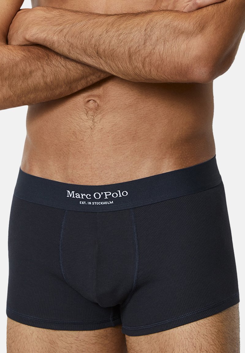 Marinblå bomullsboxer med ribbat mönster och elastisk midja med vit "Marc O'Polo" logotyp.