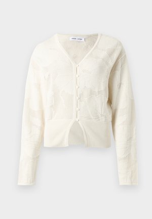 Cardigan en maille crème avec motif floral texturé, col V, manches longues, fermeture à boutons sur le devant et ourlet côtelé avec une petite fente devant.