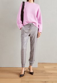 Pink fuzzy sweater, gray checkered pants with elastic cuffs and drawstring, worn with black pointed-toe heels. Textured and patterned elements present.