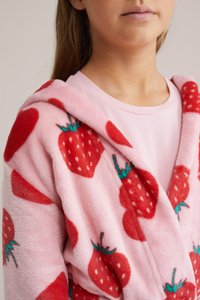 Peignoir en polaire rose avec un motif de fraises rouges aux feuilles vertes, une capuche et une texture douce. Simple top rose en dessous.
