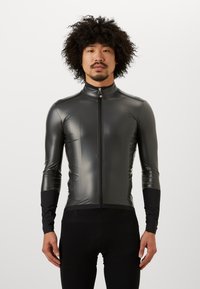 Tajt, långärmad cykeljacka i svart, gjord av glänsande, elastiskt material. Har en frontdragkedja och kontrasterande texturerade svarta muddar.