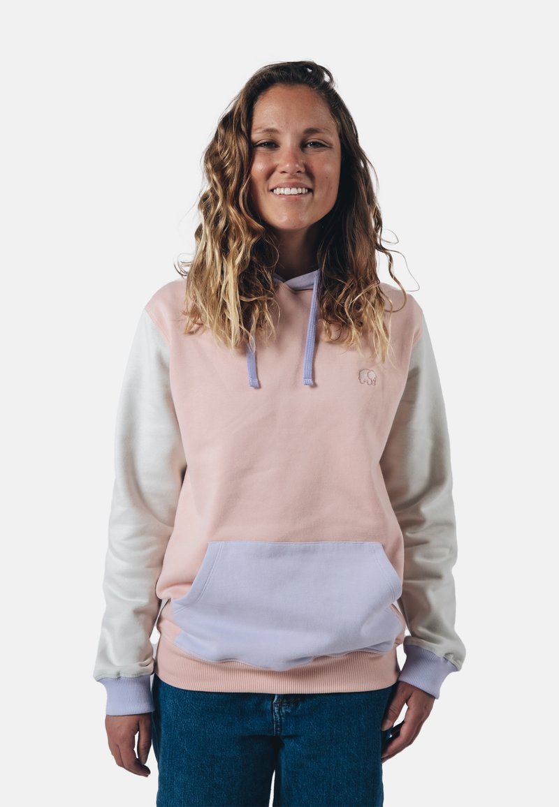 Mikina s kapucí v pastelově růžové a bílé barvě, s přední kapsou, měkkou texturou a kontrastními levandulovými šňůrkami. Vybavena vyšívaným logem.