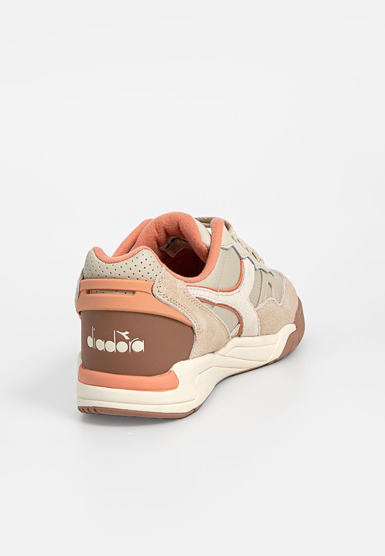Sneaker con una parte superiore in suede beige con accenti pesca, pannelli laterali testurizzati e una suola bianca. Logo sul tallone, colletto imbottito e linguetta.