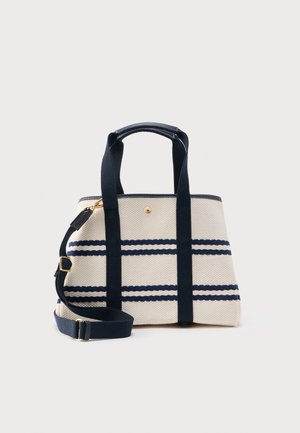 Sac cabas en toile beige à rayures horizontales bleu marine, avec deux poignées et une bandoulière réglable ornée de ferrures dorées.